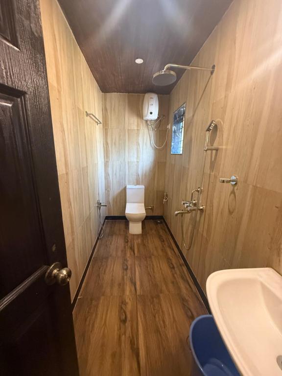 a bathroom with a toilet and a shower and a sink at Hotel White Calangute in Calangute