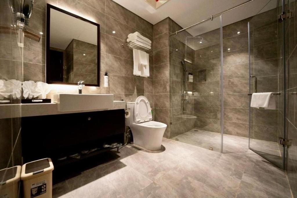 een badkamer met een toilet, een wastafel en een douche bij Sapphire House Hạ Long in Ha Long