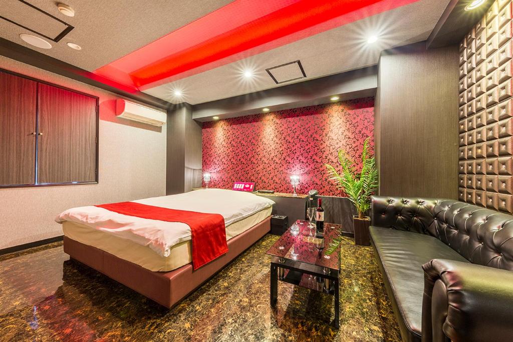 a bedroom with a bed and a couch in a room at ドンキーズジャングル千葉市店 in Chiba