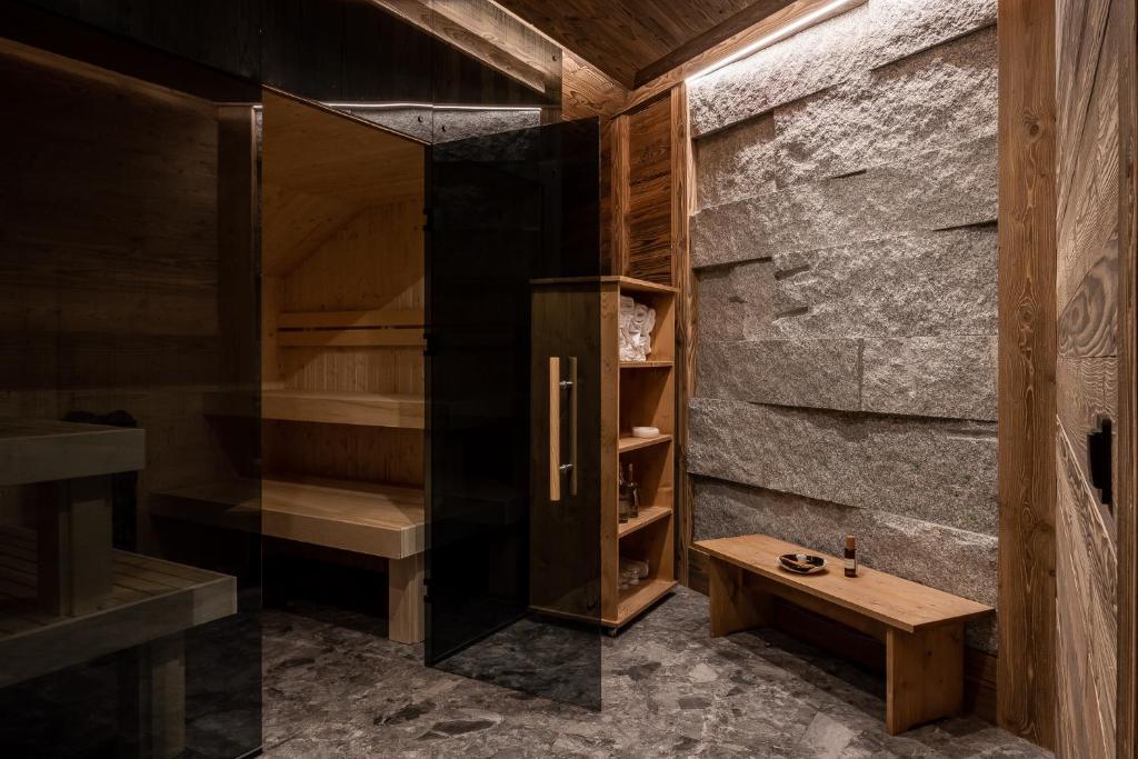een sauna met een houten bank en een stenen muur bij Villa Vita Krupówki in Zakopane