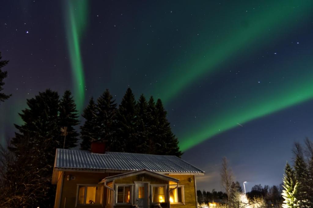 une image d'une maison avec l'aurore dans le ciel dans l'établissement Peaceful house for relaxing, à Oulu