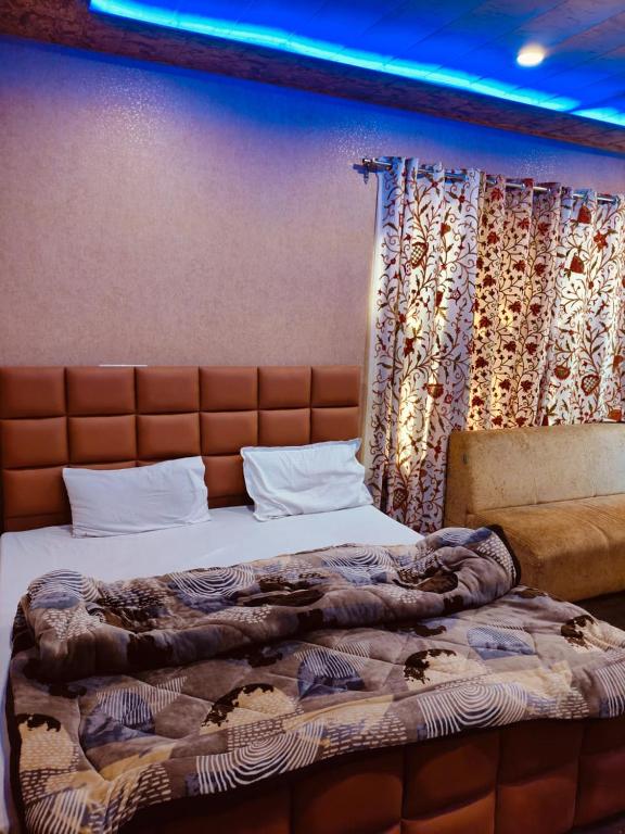 a large bed in a room with a curtain at Hotel taimoor in Srinagar