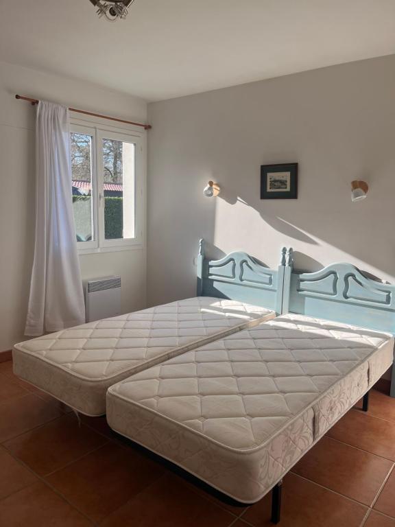 ein Schlafzimmer mit einem großen Bett in einem Zimmer mit Fenster in der Unterkunft Maison chaleureuse in Mézos