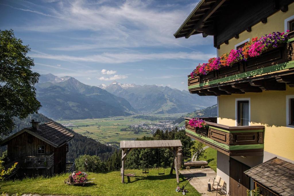 a building with flowers on the balconies with a view at Bio Bauernhof Holzegghof in Zell am See in Erlberg