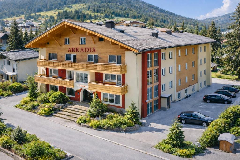 an apartment building in the mountains with a parking lot at Arkadia Apartments in Bad Hofgastein