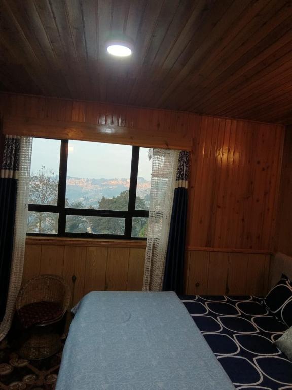 a bedroom with a bed and a large window at Ghising Newas Homestay in Jālāpahār