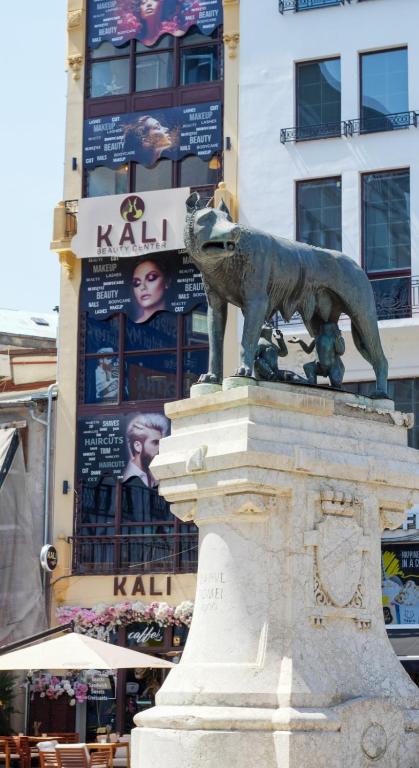 a statue of a dog on top of a building at KALI Old Town LOFT with Monument view in Bucharest