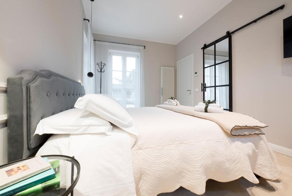 een witte slaapkamer met een groot bed met witte kussens bij Residence Briona in Domodossola