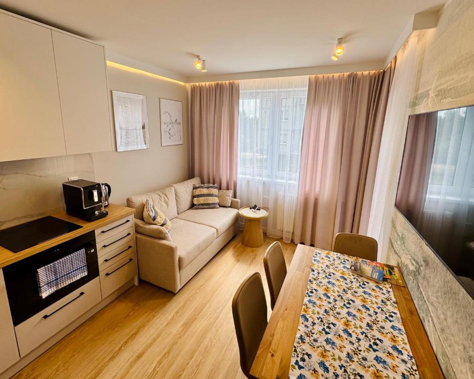 a small living room with a couch and a table at Modrzewiowa Przygoda in Debina
