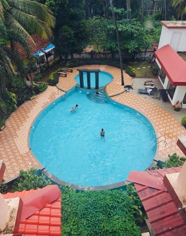 een bovenaanzicht van een zwembad met mensen erin bij URA Beach Goa in Calangute