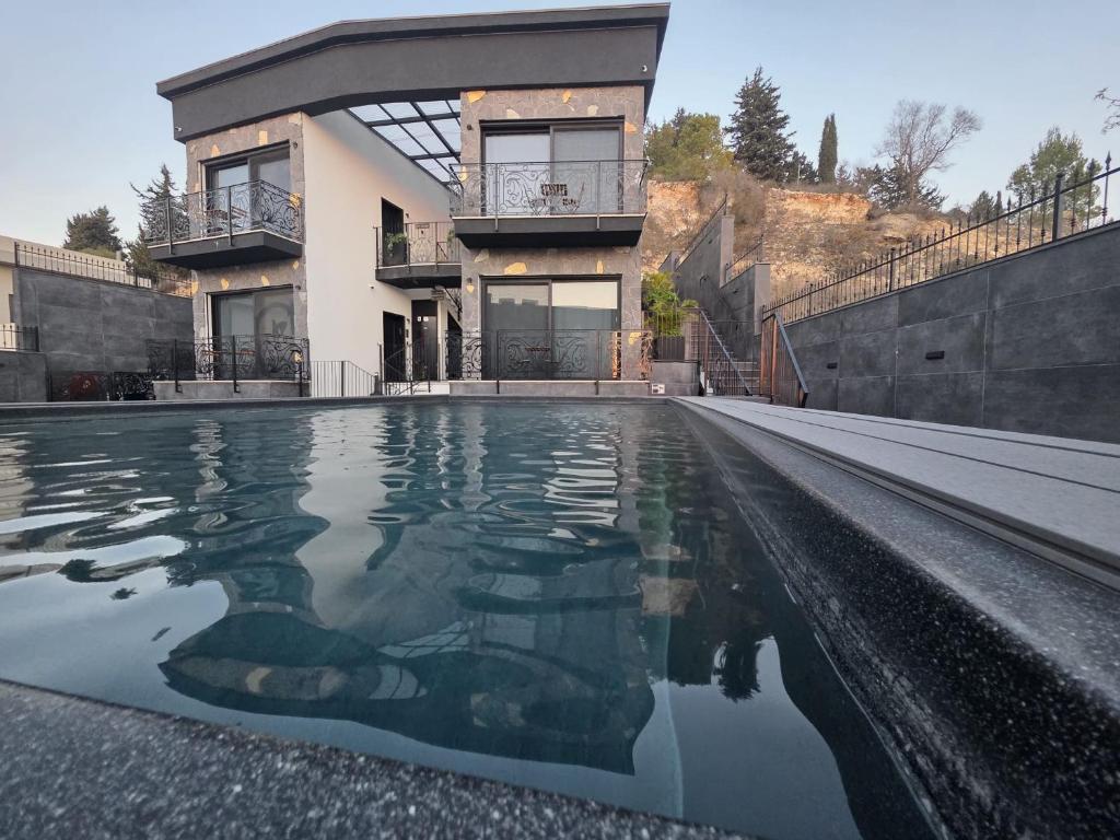 a house with a swimming pool in front of a house at Cesia Boutique - ססיה סוויטות בוטיק in Biriyya