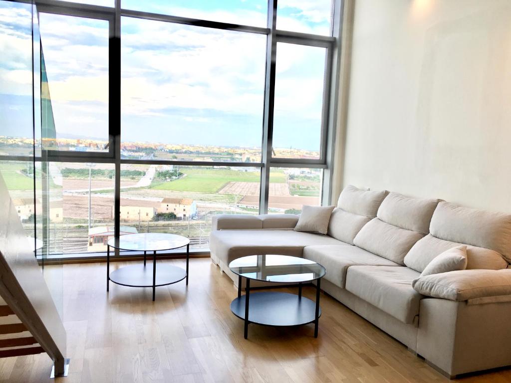 een woonkamer met een bank en twee tafels bij Panoramic Suites II By VALENCIAFLATS EU in Valencia