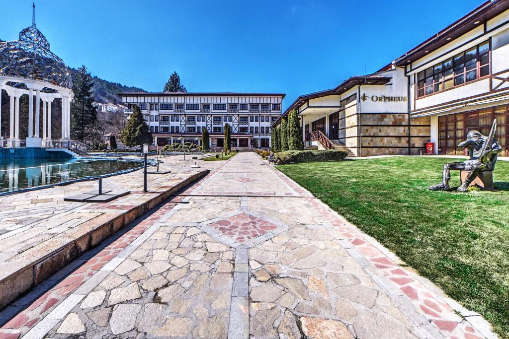 een loopbrug voor een groot gebouw bij Спа Хотел Орфей in Devin