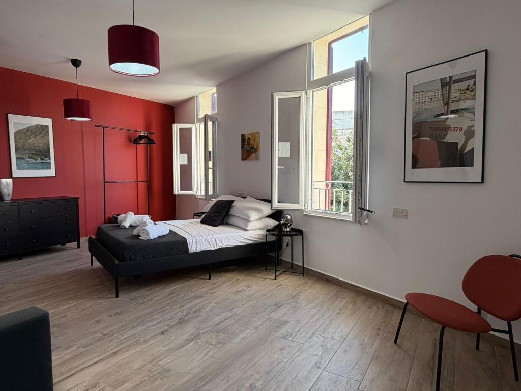 een slaapkamer met een bed in een kamer met rode muren bij Peprina Apartment 1 - Central Rabat - NEW 2025 in Rabat