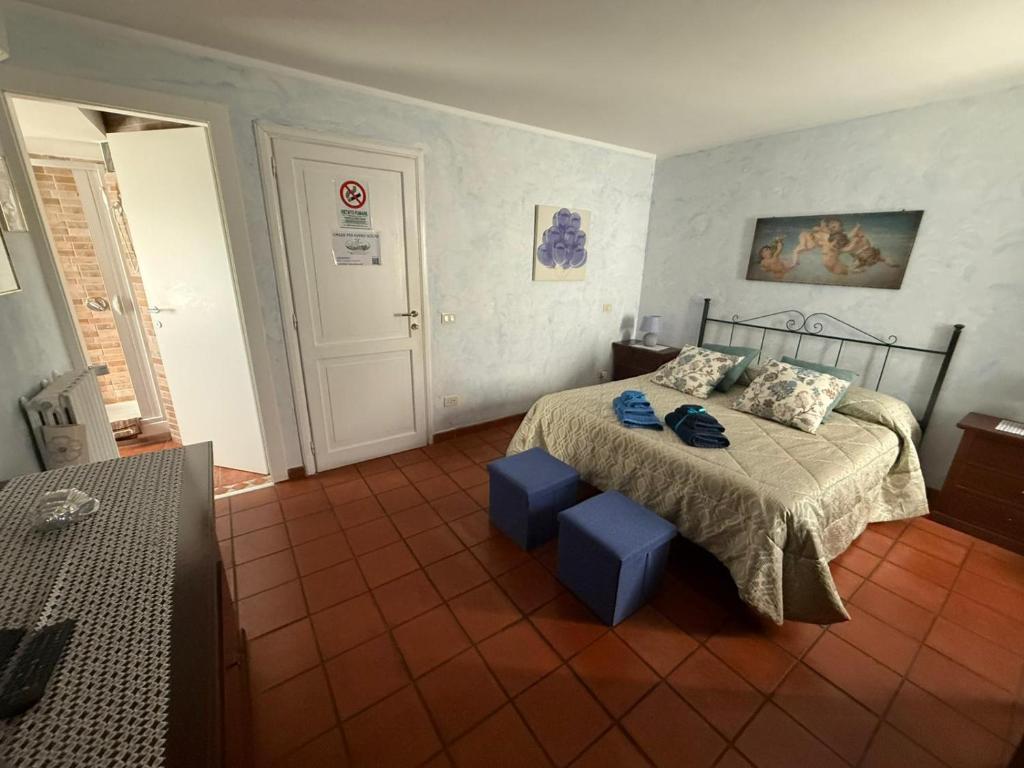 ein Schlafzimmer mit einem Bett, zwei blauen Hockern und einem Bettgestell in der Unterkunft Centro Storico in Anagni