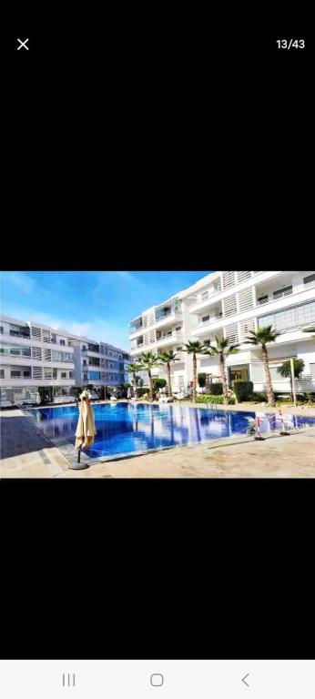 una persona che cammina davanti a un grande condominio di Apparemment a Minaret de Mansuria