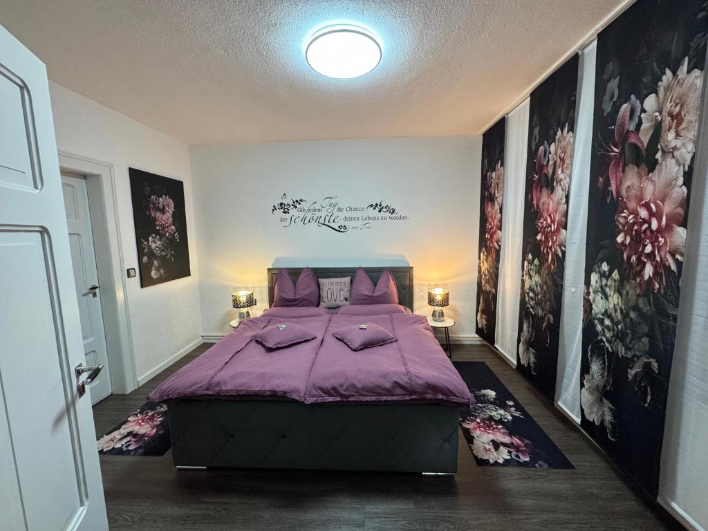 een slaapkamer met een paars bed en schilderijen aan de muren bij Lieblingsplatz in Eisenach