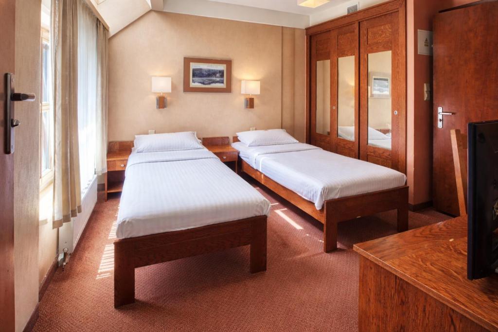 En eller flere senge i et værelse på Dom Oliwski