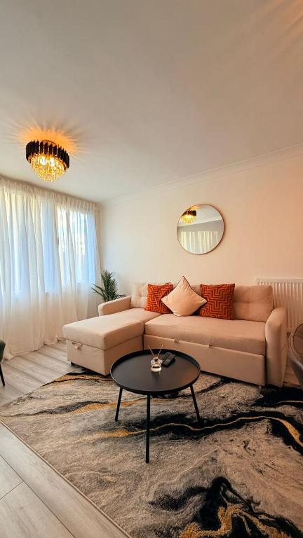 a living room with a couch and a table at Modern 1 bed super fast WiFi in Brentford