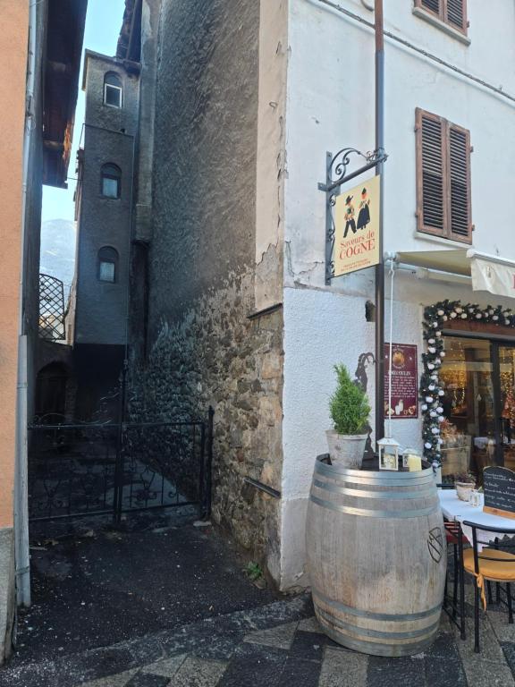 Ein Weinfass steht neben einem Gebäude mit einem Schild in der Unterkunft Maison Berthod in Aosta