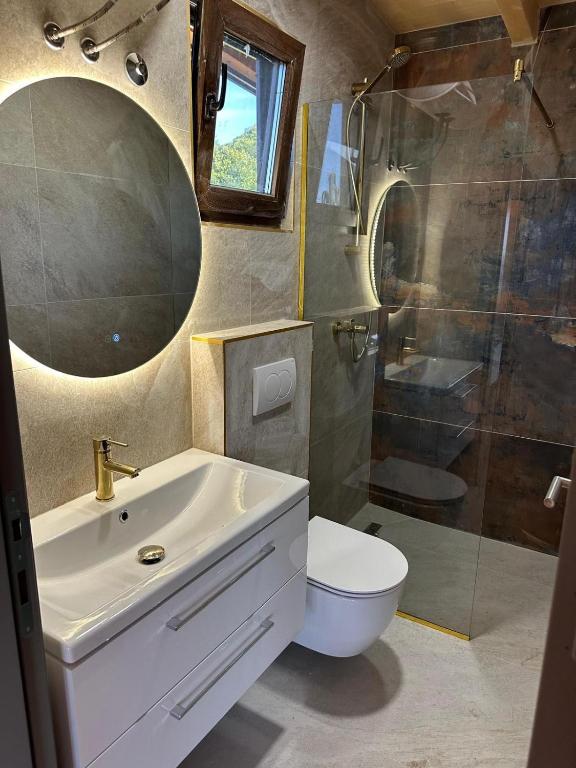 a bathroom with a sink and a toilet and a shower at Suncatcher Djurdjevic Apartmani in Banja Luka