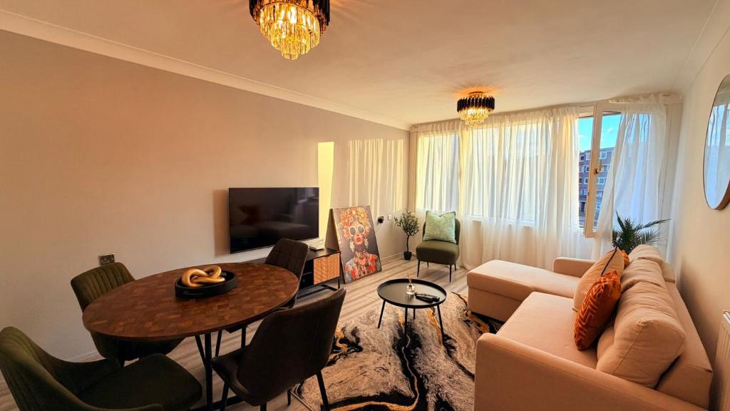 un salon avec un canapé et une table dans l'établissement Modern 1 bed super fast WiFi, à Brentford