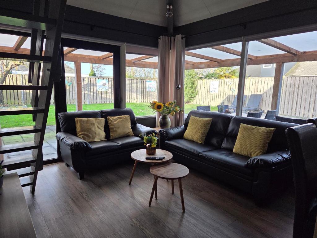 een woonkamer met een zwarte bank en een tafel bij Zeeuwse Luwte in Stavenisse