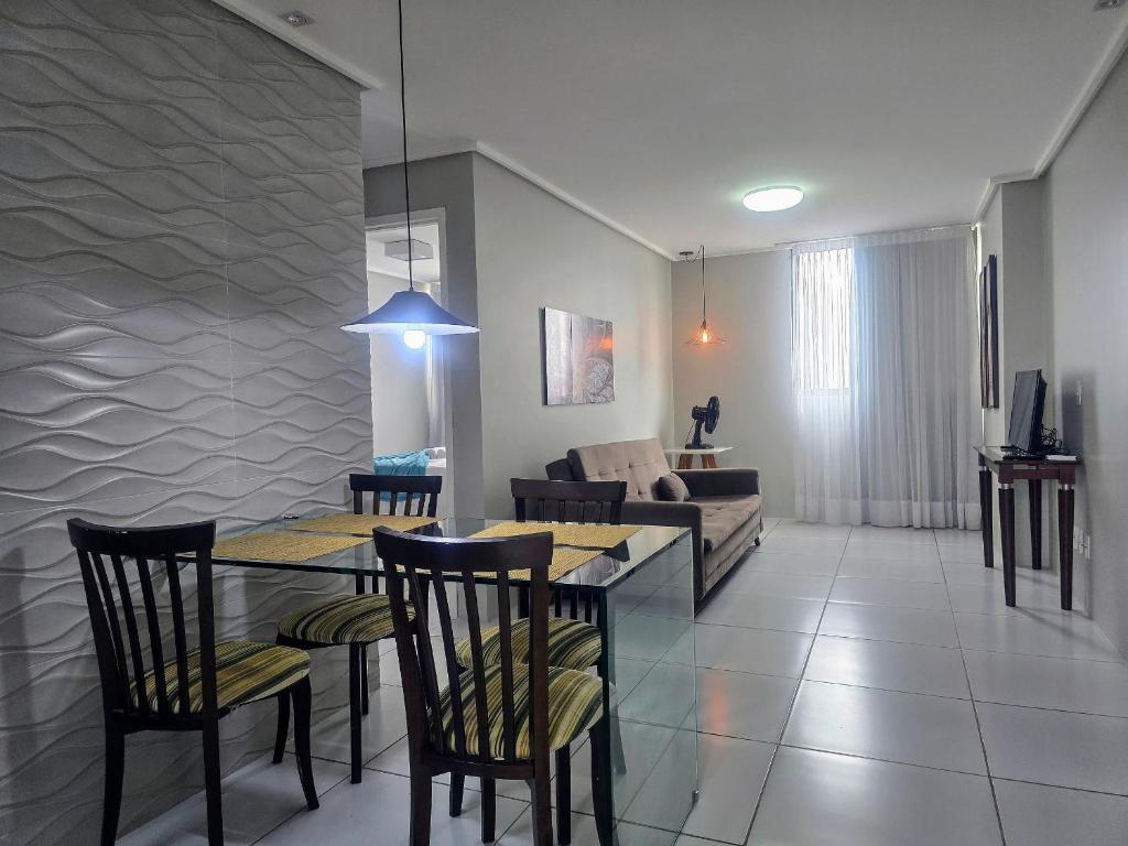 een woonkamer met een tafel, stoelen en een bank bij Ed. Manoel Cordeiro - Stúdio Meu aconchego II in Caruaru