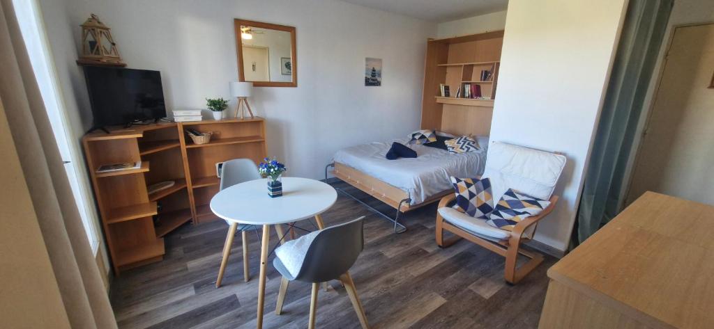 een kleine kamer met een bed en een tafel en stoelen bij Studio à 10min à pieds des Cures in Gréoux-les-Bains