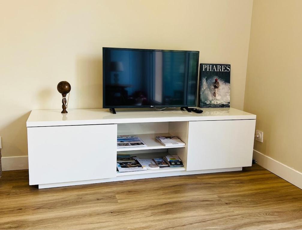 a white entertainment center with a television on top of it at L'esprit vacances-T3 à Port La Forêt in La Forêt-Fouesnant