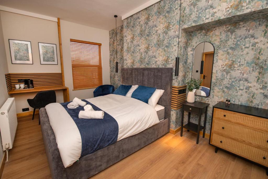 a bedroom with a bed and a desk and a mirror at Amber Serviced Rooms - Free parking Self Check-In with access to shared kitchen in Hull
