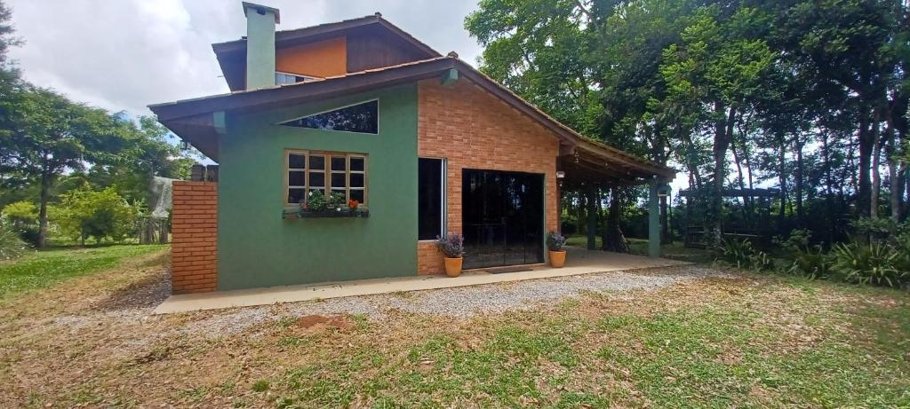 een klein huis met een dak op een veld bij Birds' Corner Cabin in Curitiba