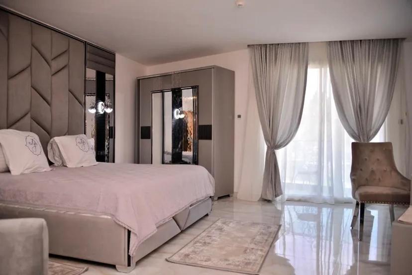 a bedroom with a large bed and a large window at HOTEL Diar Jenna in Annaba