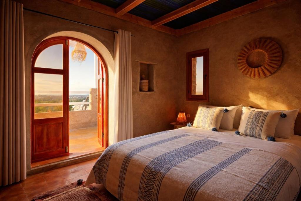 una camera da letto con un letto grande e una grande finestra di Tigmi berber a Essaouira