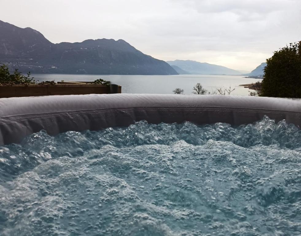Tiny-Pool-Lake في لو فيفيي دو لاك: حوض استحمام ساخن به ماء بجوار مسطح مائي