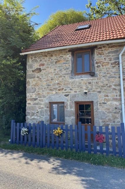 a blue fence in front of a stone house at La Vache Bleue in Saint-Pierre-de-Fursac