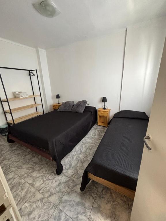 een slaapkamer met twee bedden en twee nachtkastjes bij Hotel gade in Mar del Plata