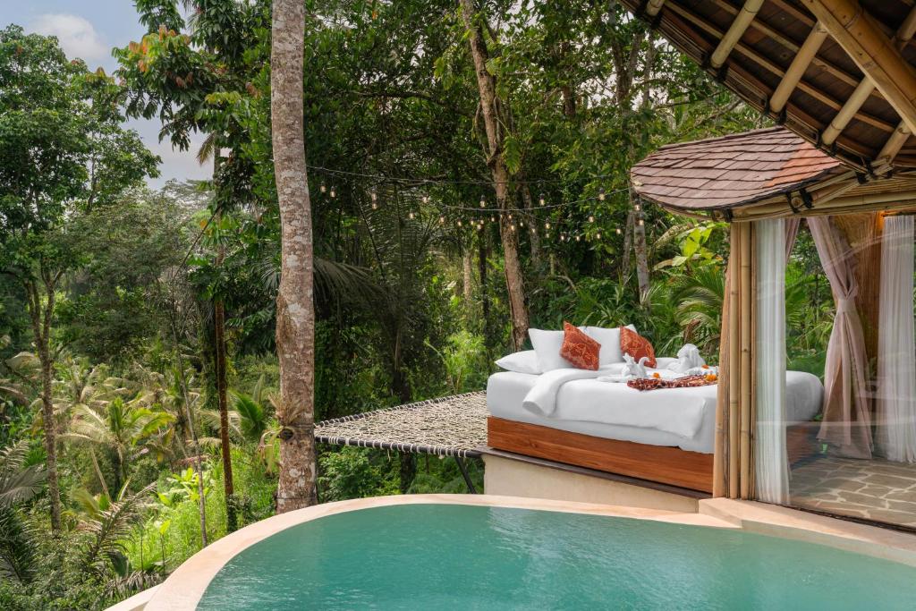 een villa met een bed en een zwembad bij Umawana Villas in Tegalalang