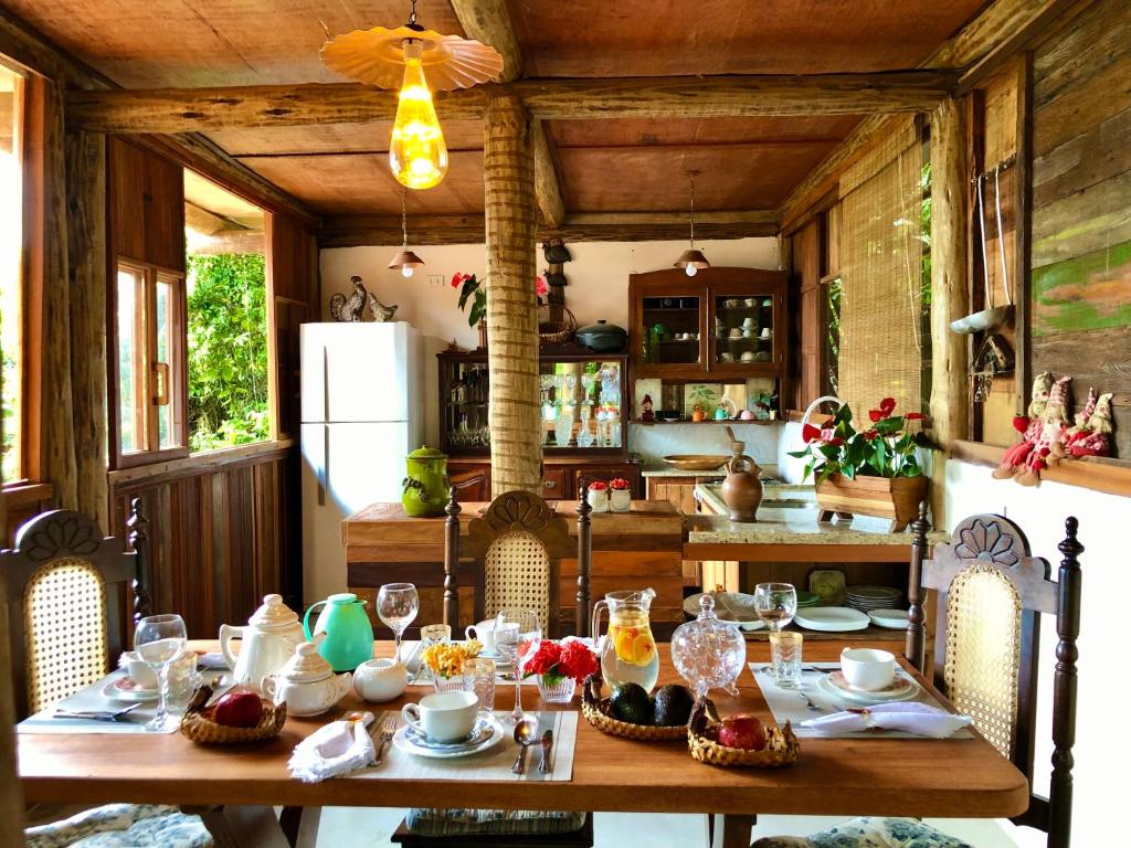 une cuisine avec une table en bois et des chaises ainsi qu'une salle à manger dans l'établissement Eliza, Bangalô vista mar em Trancoso, à Trancoso