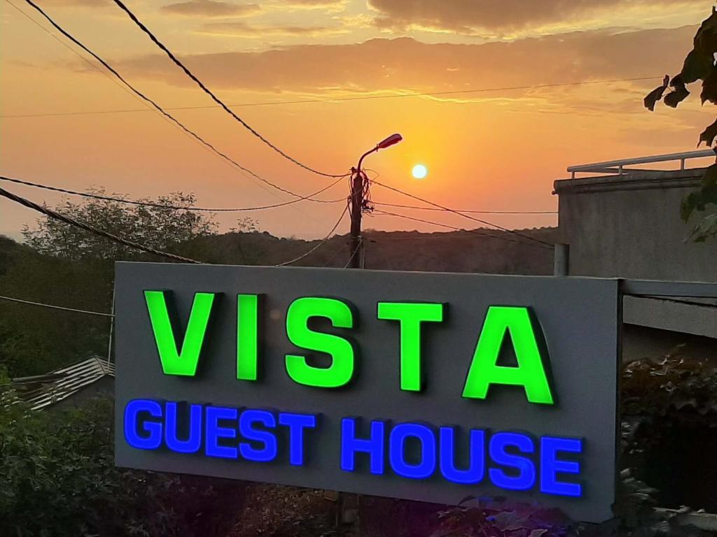 une enseigne de maison d'hôtes avec le coucher du soleil en arrière-plan dans l'établissement Guest House Vista, à Sighnaghi