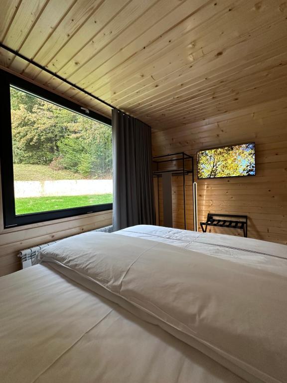 a bedroom with a large bed with a large window at Hotel McPietroasa in Haleş