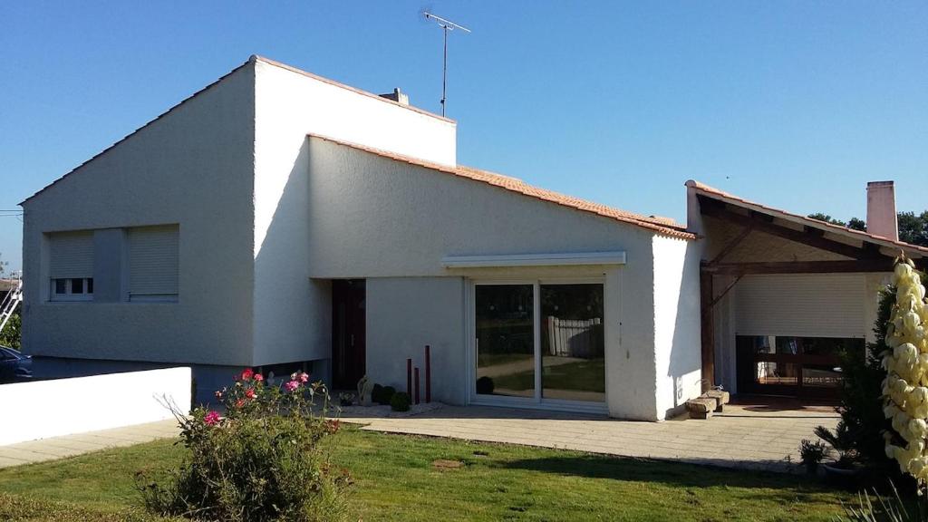 a white building with a large glass door at Les chataigniers in Apremont