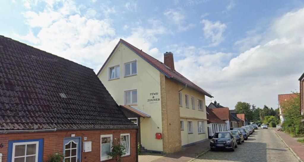 une rue dans une petite ville avec des voitures garées dans l'établissement Ferienwohnung für Handwerker, à Kappeln