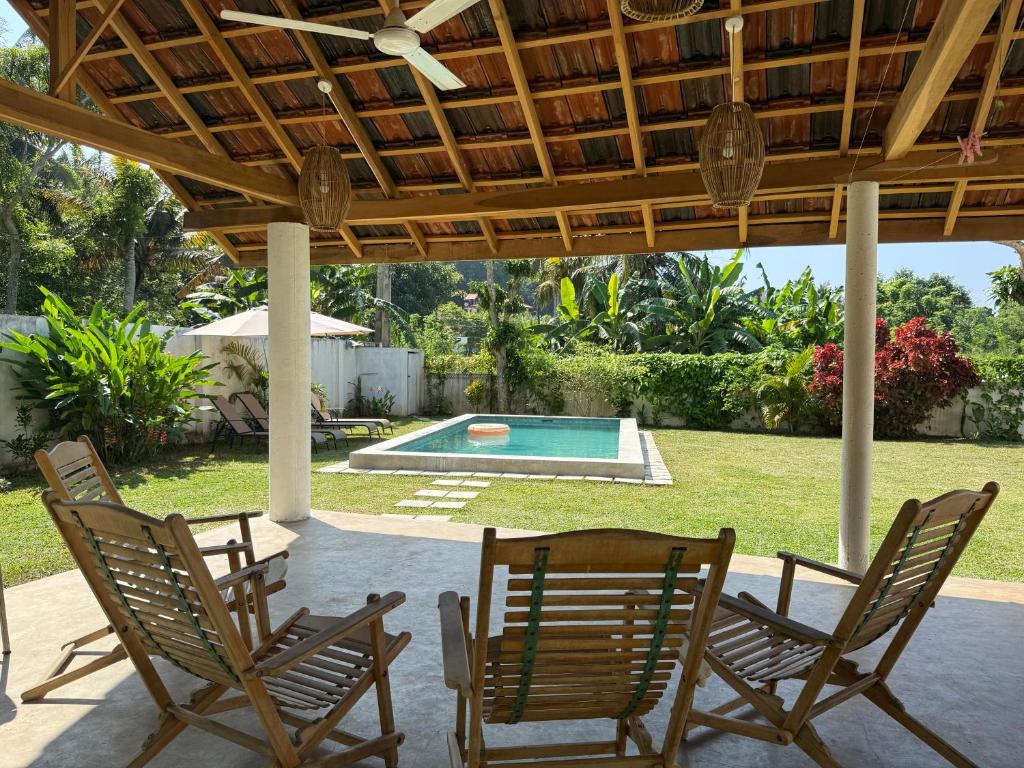 een terras met stoelen en een tafel en een zwembad bij Villa Carla Mirissa in Mirissa