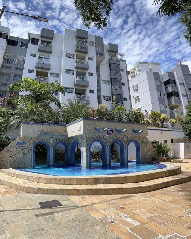 a swimming pool in front of a large building at Refúgio das Thermas in Caldas Novas