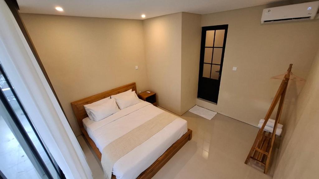a small bedroom with a bed and a window at Kalih Rooms in Ubud