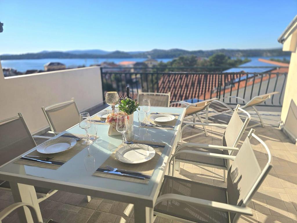 een witte tafel en stoelen op een balkon bij Apartmani Krnić in Šibenik