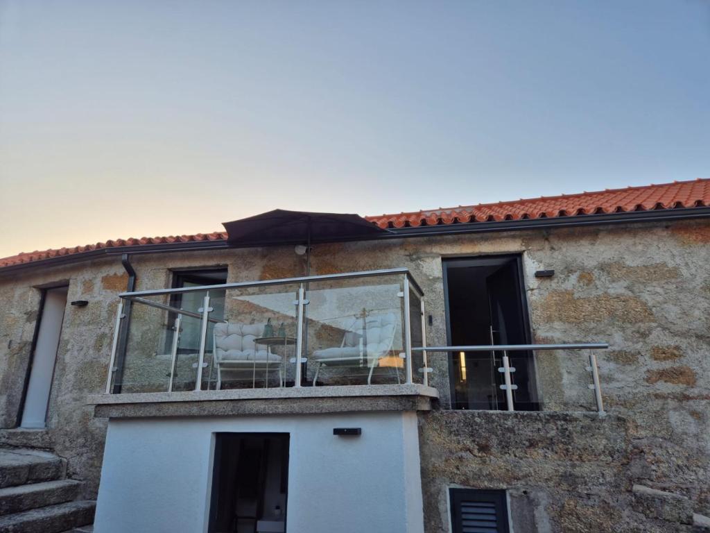 a house with a glass balcony on the side of it at O Cantinho D'Alice in Sabugal