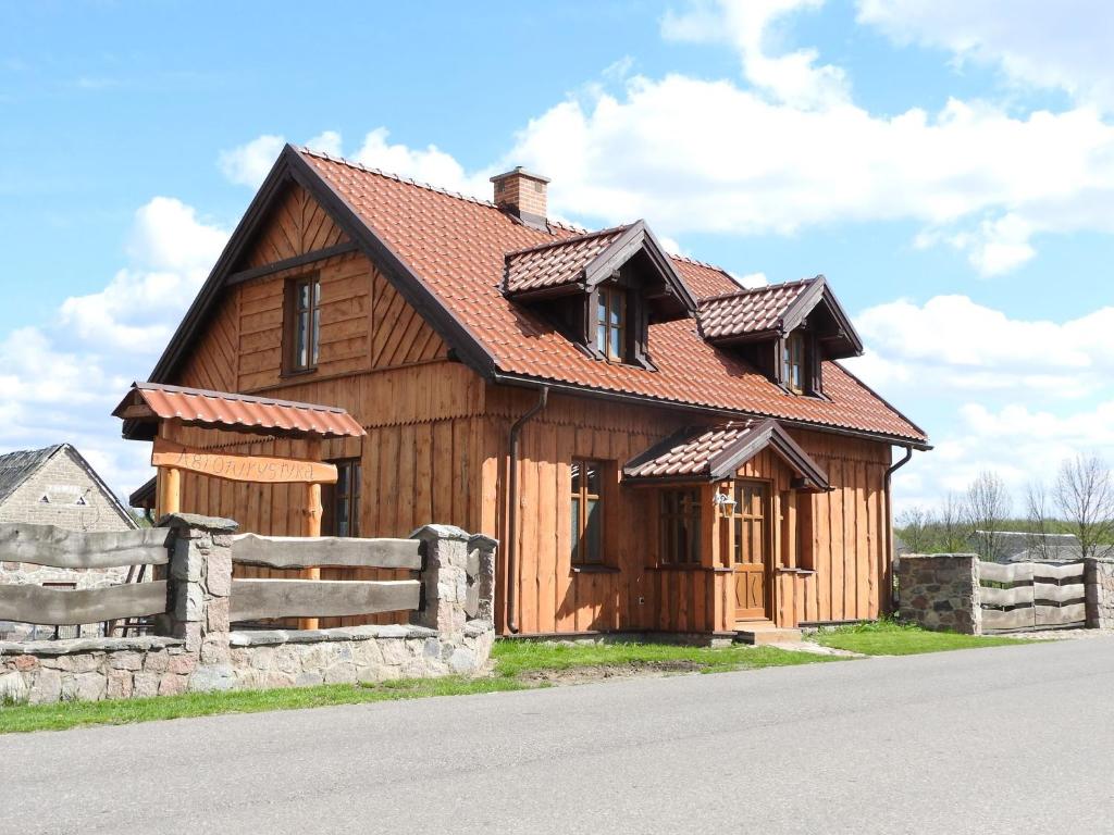una casa in legno con una recinzione di fronte ad essa di Agroturystyka Biebrzańska Kraina a Pluty
