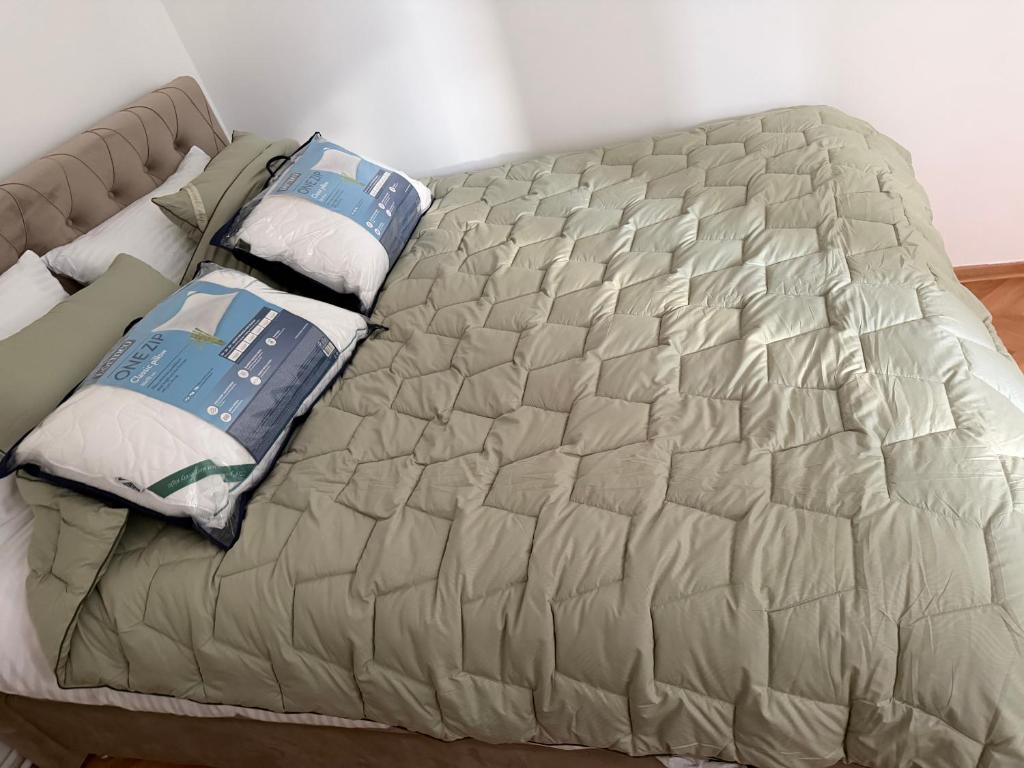 een bed met kussens erop in een slaapkamer bij Petra Apartments in Jagodina